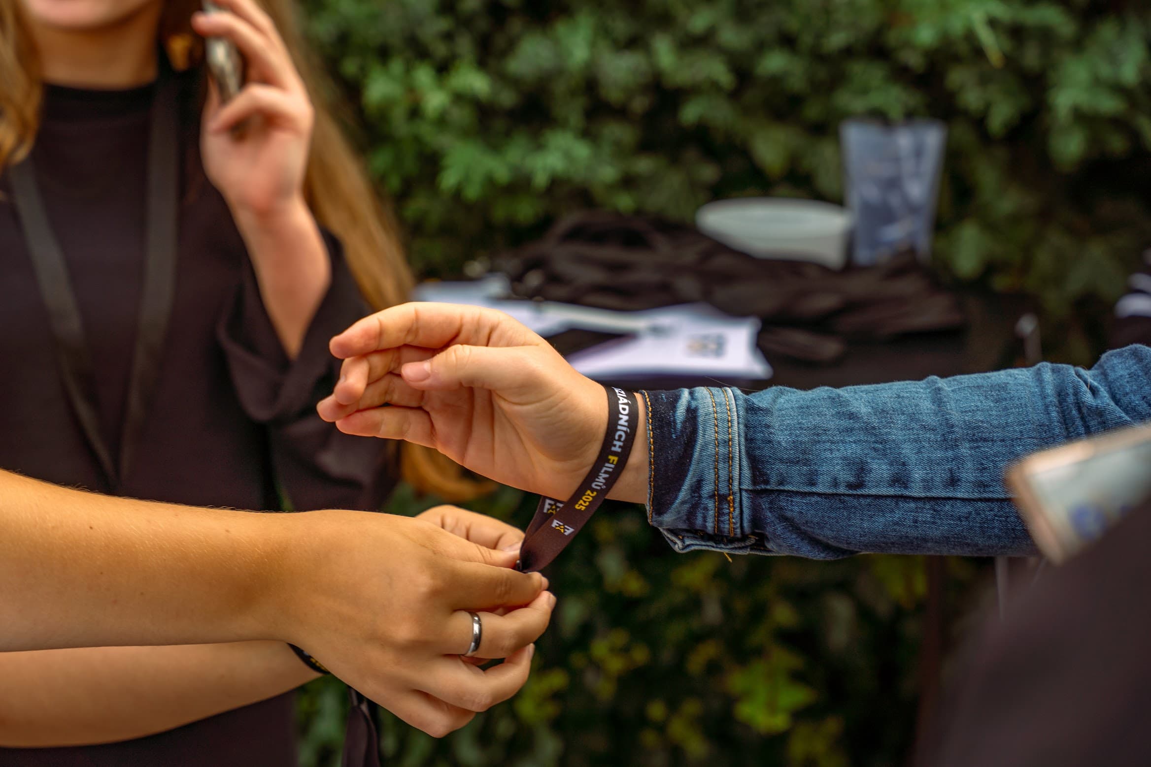 Nasazování festivalového náramku před vstupem na Ambrofest